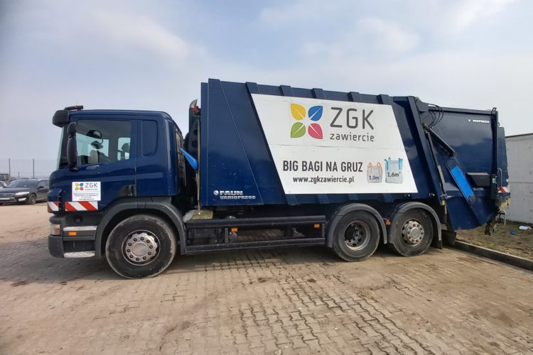Granatowy samochód ciężarowy typu śmieciarka